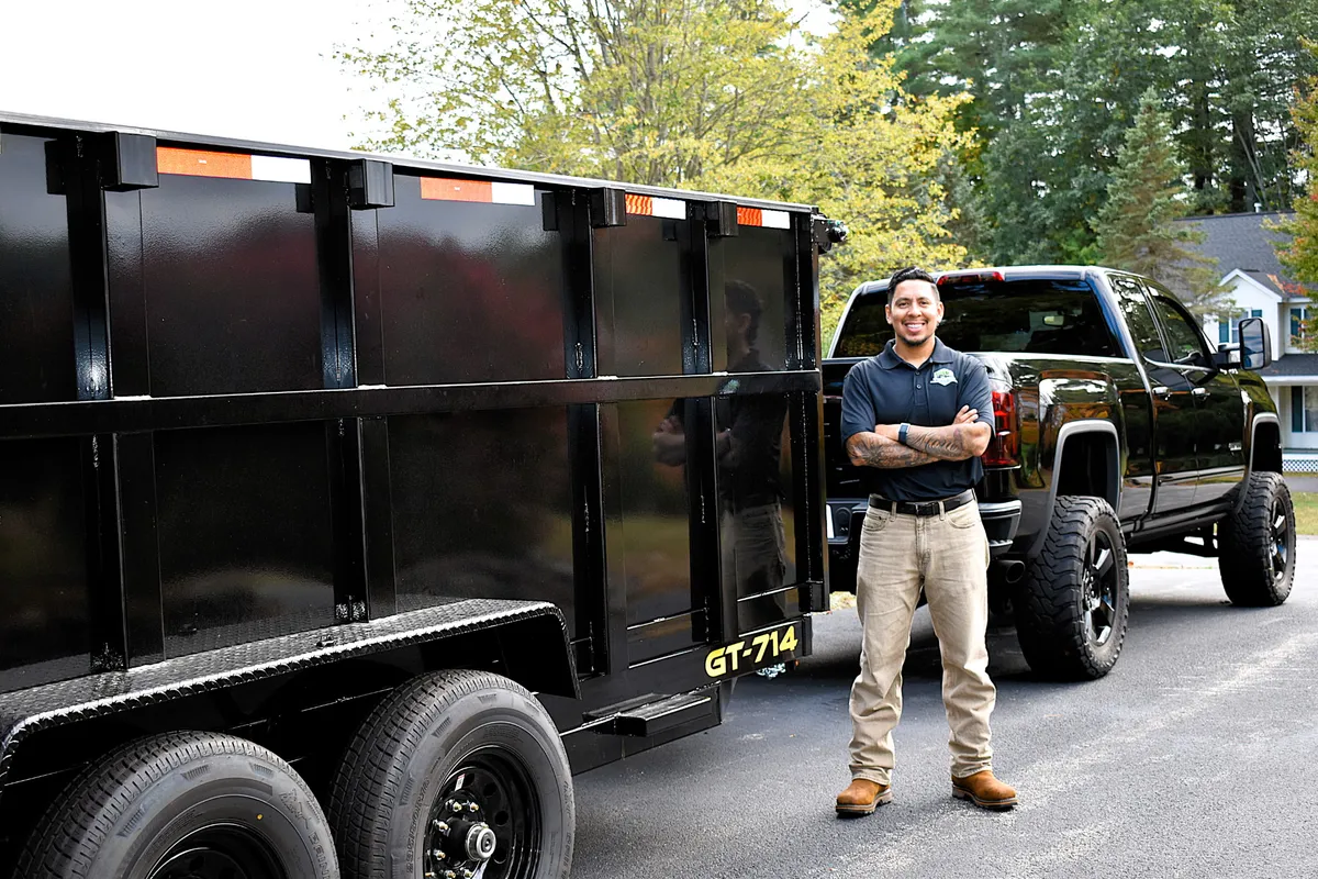James Toupin with his arms crossed beside his truck and the Toupin Hauling dump trailer