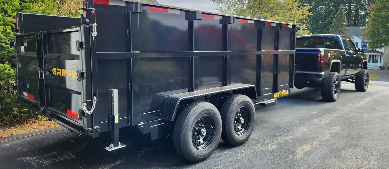 The Toupin Hauling dump trailer hitched to the pickup in a driveway