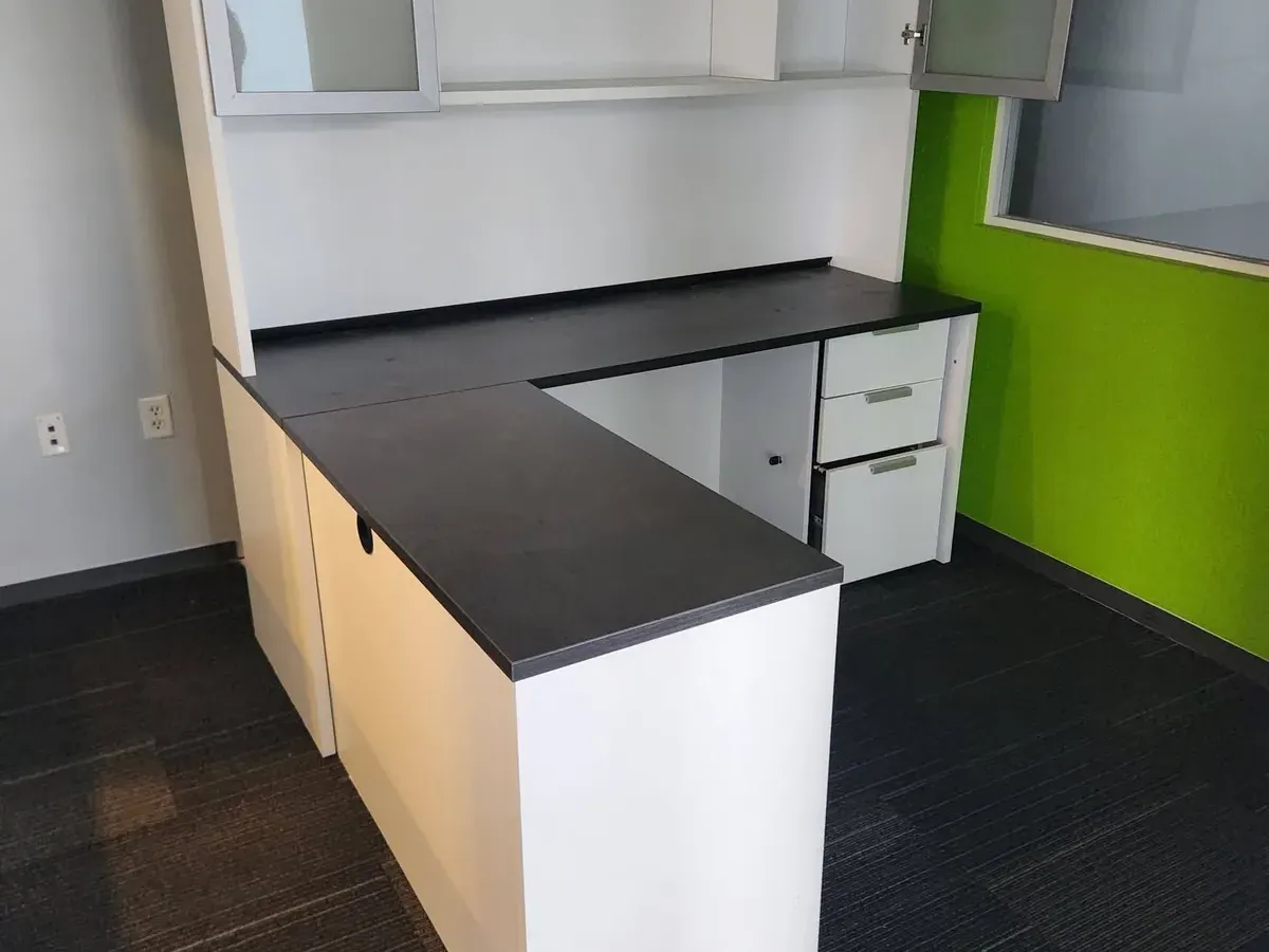 L-shaped office desk with a hutch and filing drawers in an office