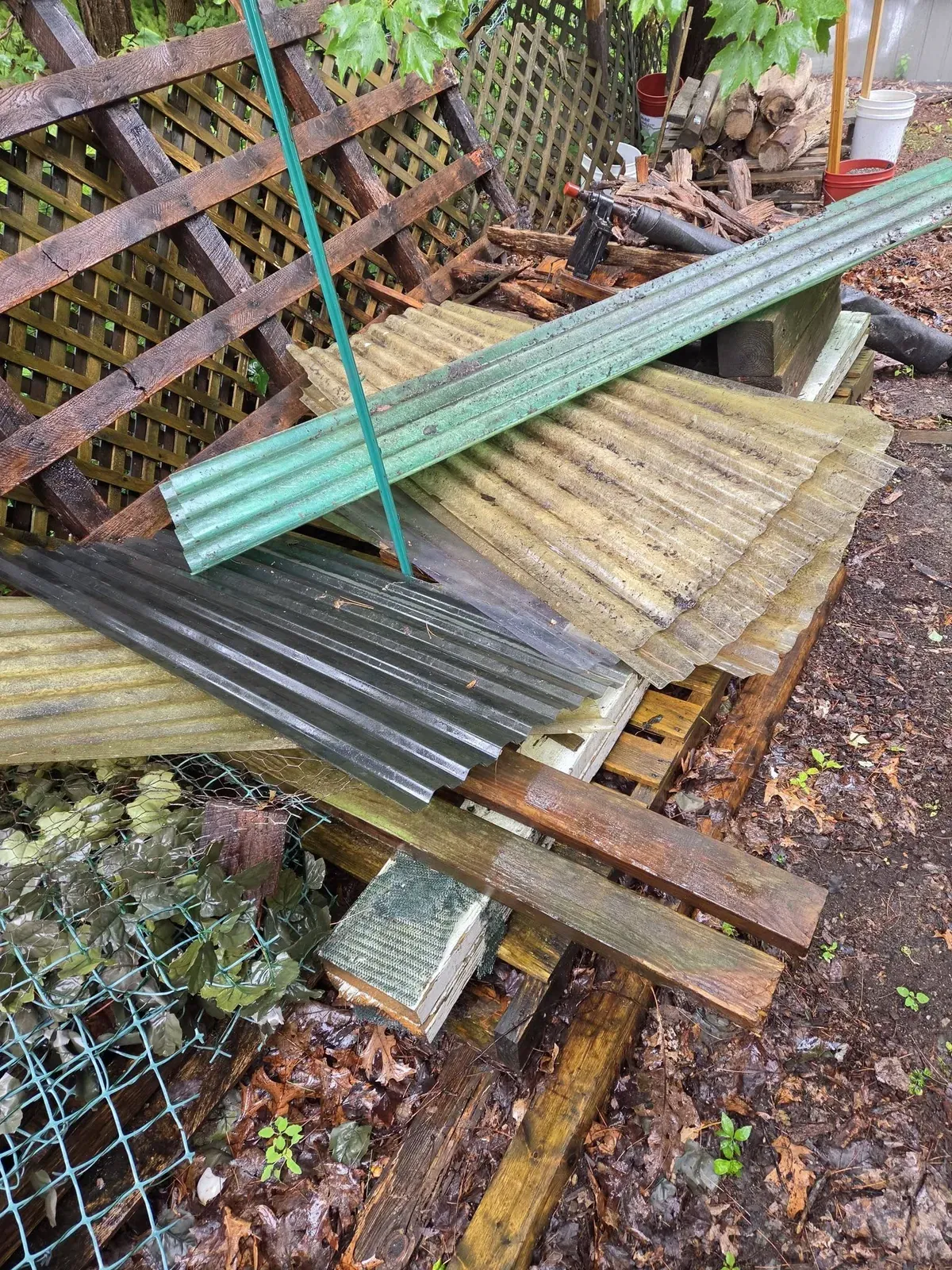 Corrugated panels, lattice and rotted boards piled together