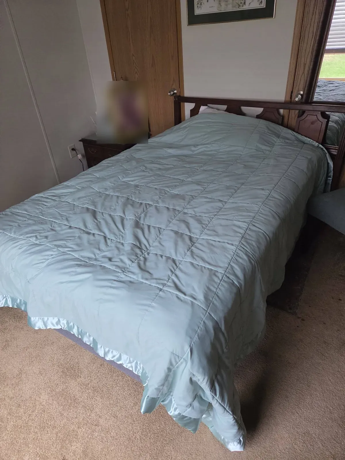 Made bed in a bedroom before an estate cleanout