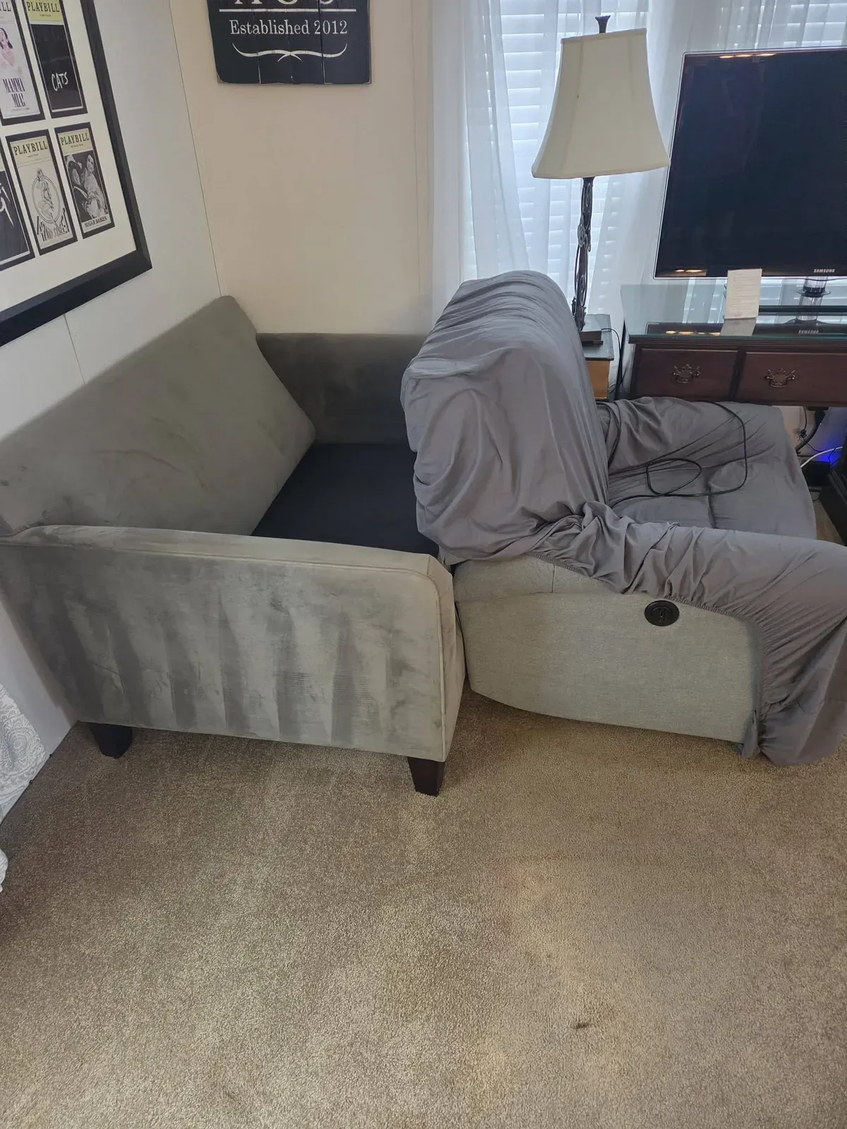 Grey sectional with a cover in a living room before an estate cleanout