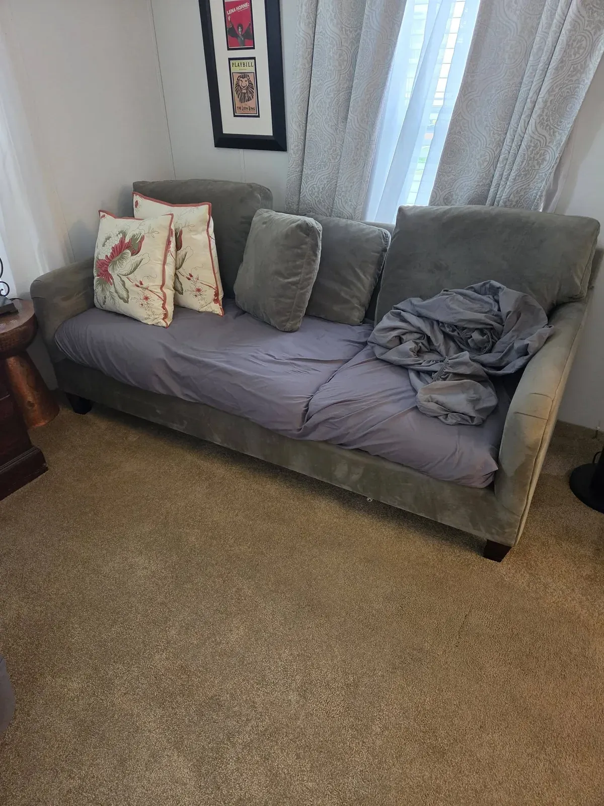 Sofa with pillows and a blanket in a living room before an estate cleanout