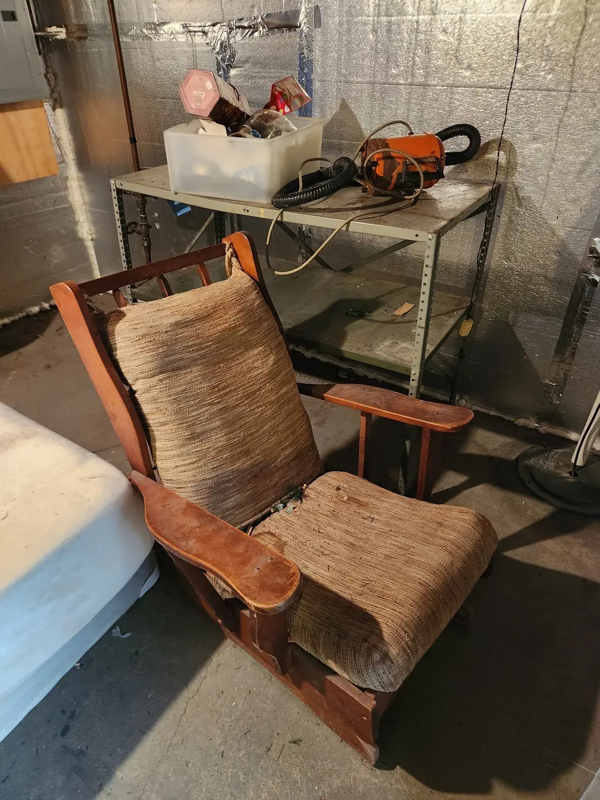 Old wooden rocking chair and a table of clutter in a basement