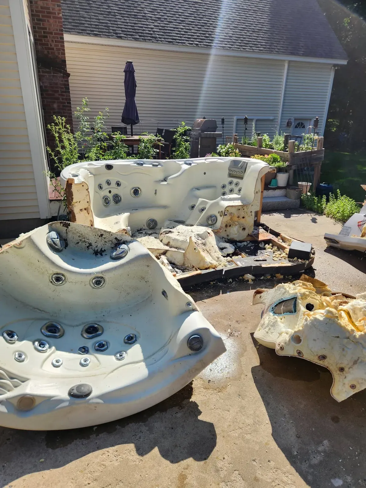 Hot tub shell cut into pieces on a patio