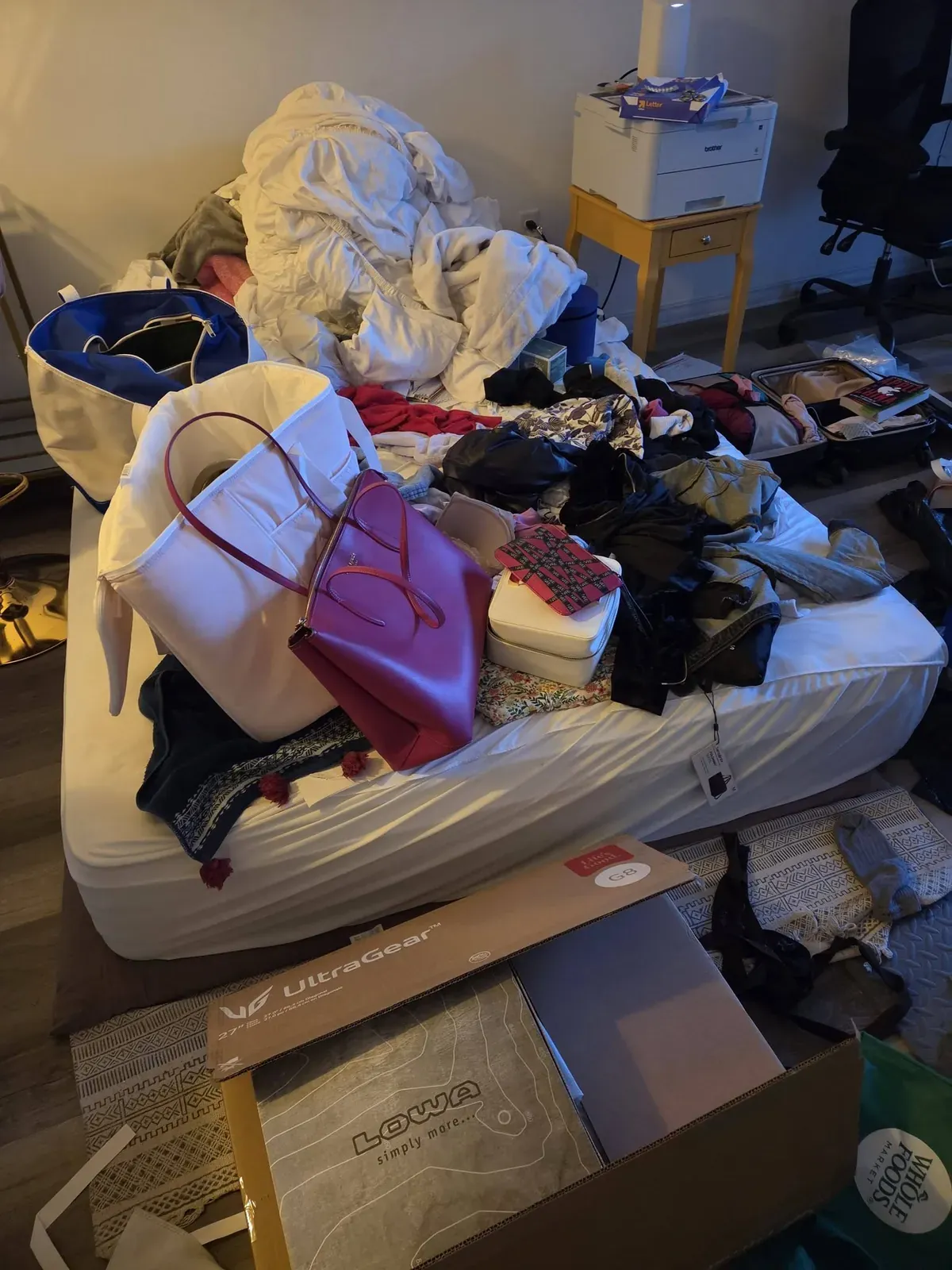 Mattress piled with clothes, bags and belongings