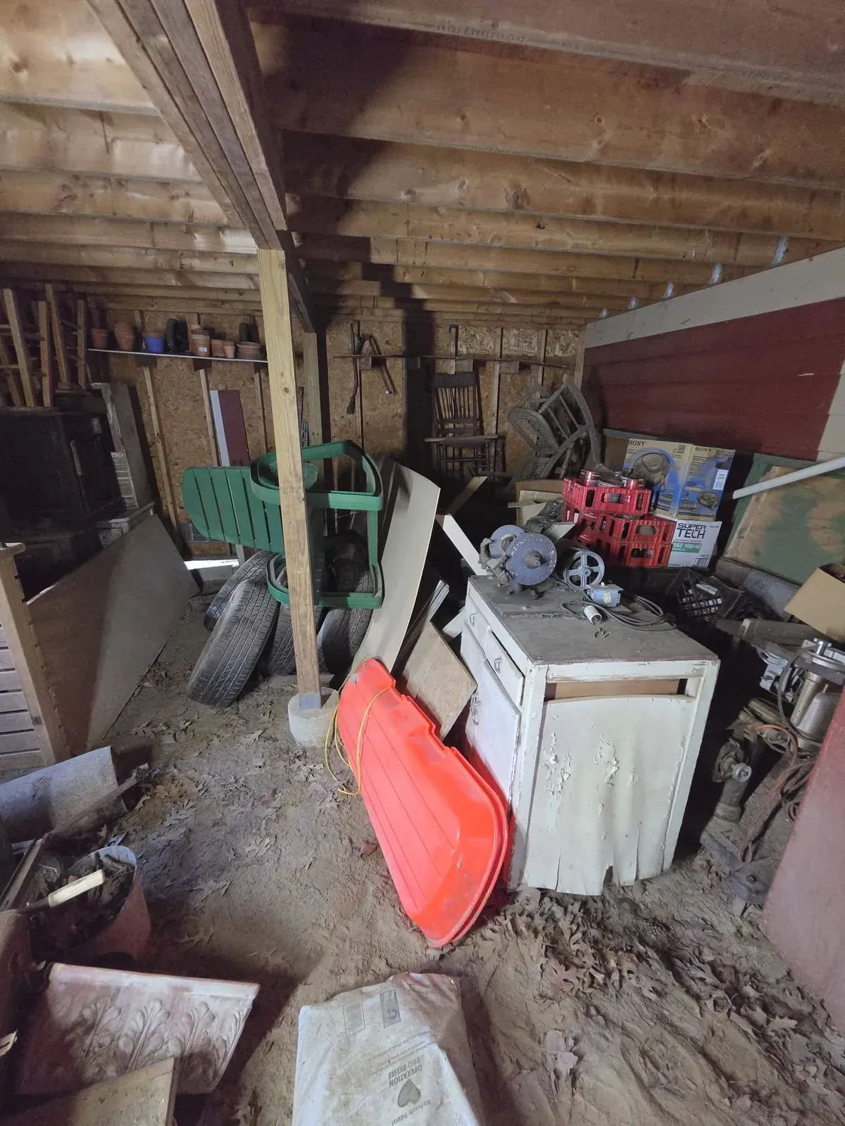 Shed packed with tools, a cabinet, tires and old equipment