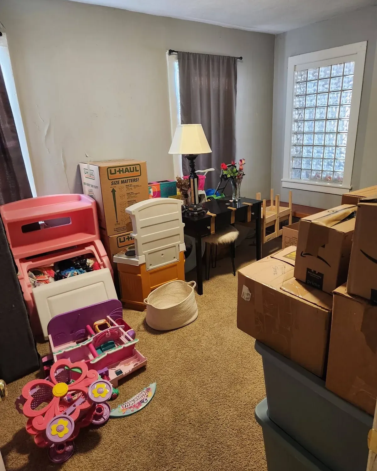 Spare room filled with moving boxes, a toy kitchen and children's toys
