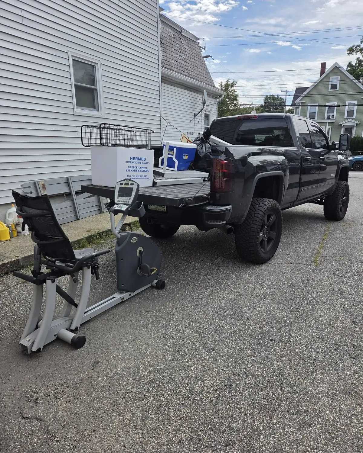 Recumbent exercise bike and boxes beside the pickup, ready to load